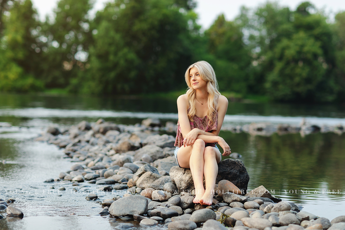 Beautiful senior portrait of a Bend high school senior in Eugene at sunset sitting on rocks along the Willamette River by Holli True Photography
